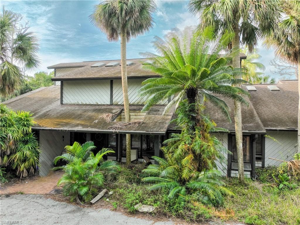 Rear view of house featuring a shingled roof
