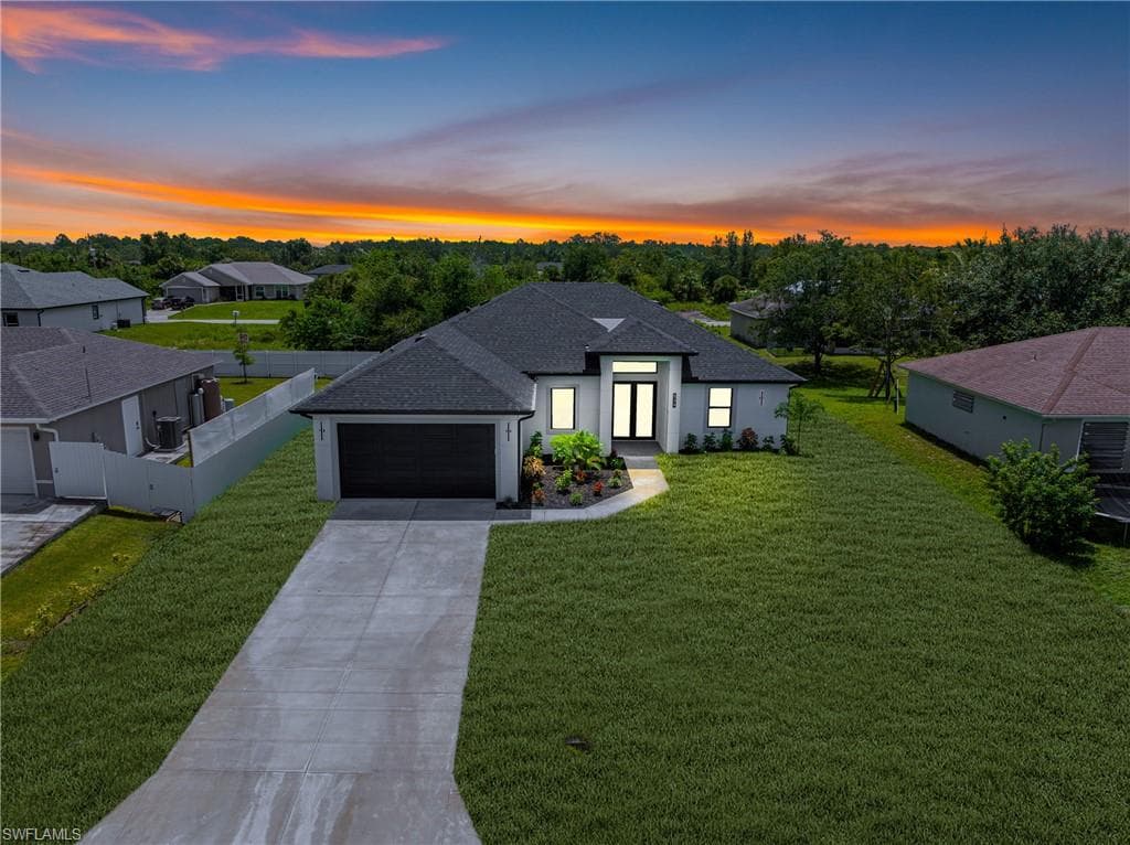View of front of home with roof with shingles, driveway, an attached garage, a residential view, and stucco siding