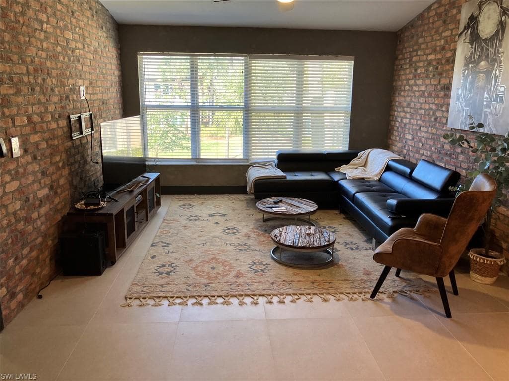 Living area featuring brick wall and an accent wall