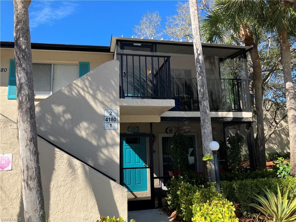 View of front of house featuring a balcony and stucco siding