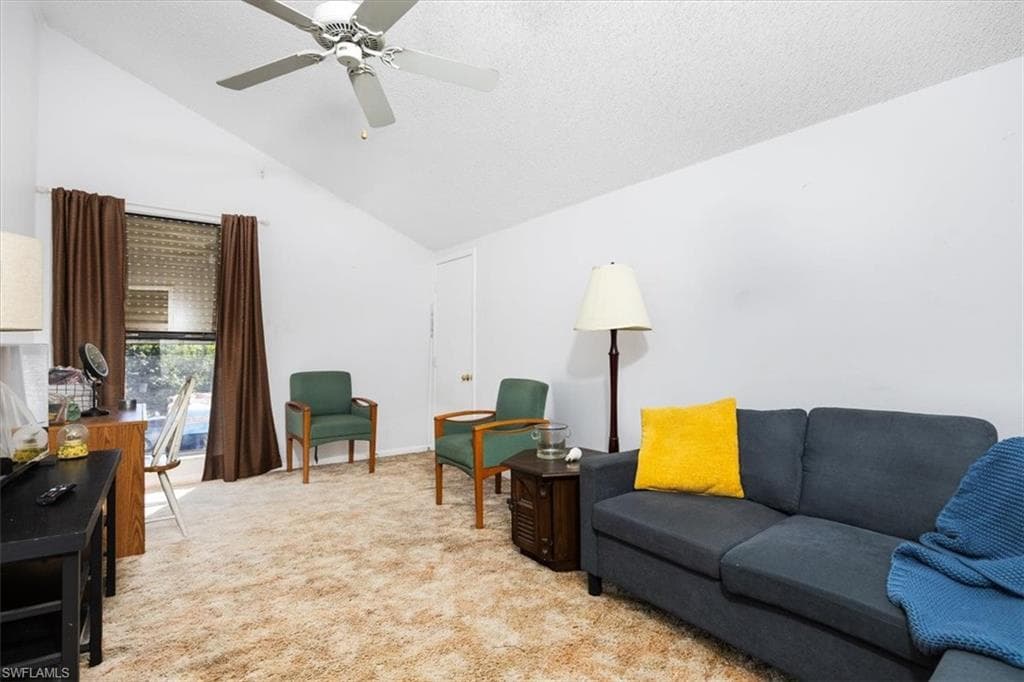 Living room featuring light carpet and a ceiling fan