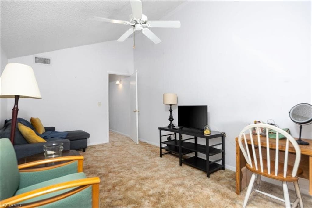 Living area featuring light carpet and a ceiling fan
