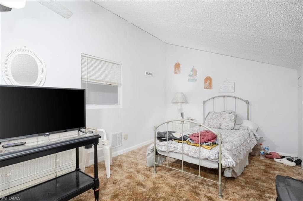 Bedroom featuring carpet flooring, a textured ceiling, and a ceiling fan