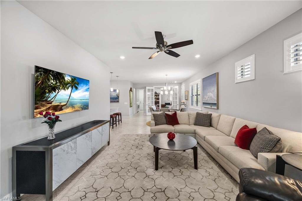 Living area featuring tile flooring, natural light connects to dining area