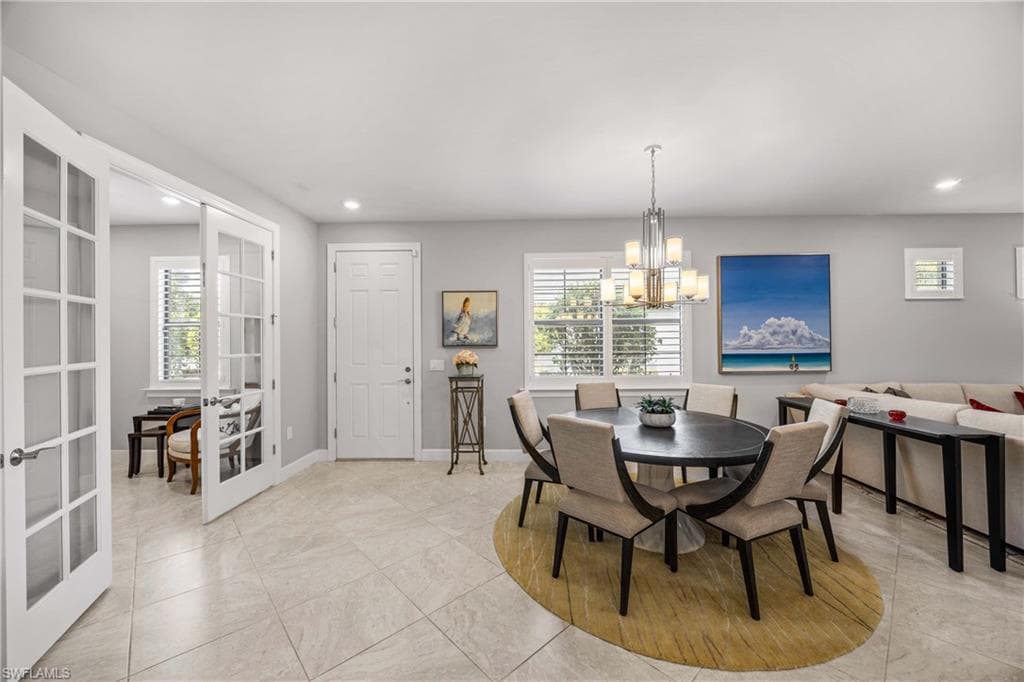 Dining area with entrance to den with French doors