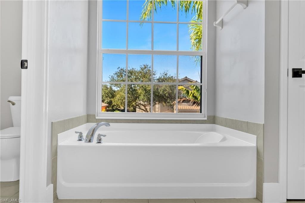 Bathroom with a garden tub and light tile patterned flooring