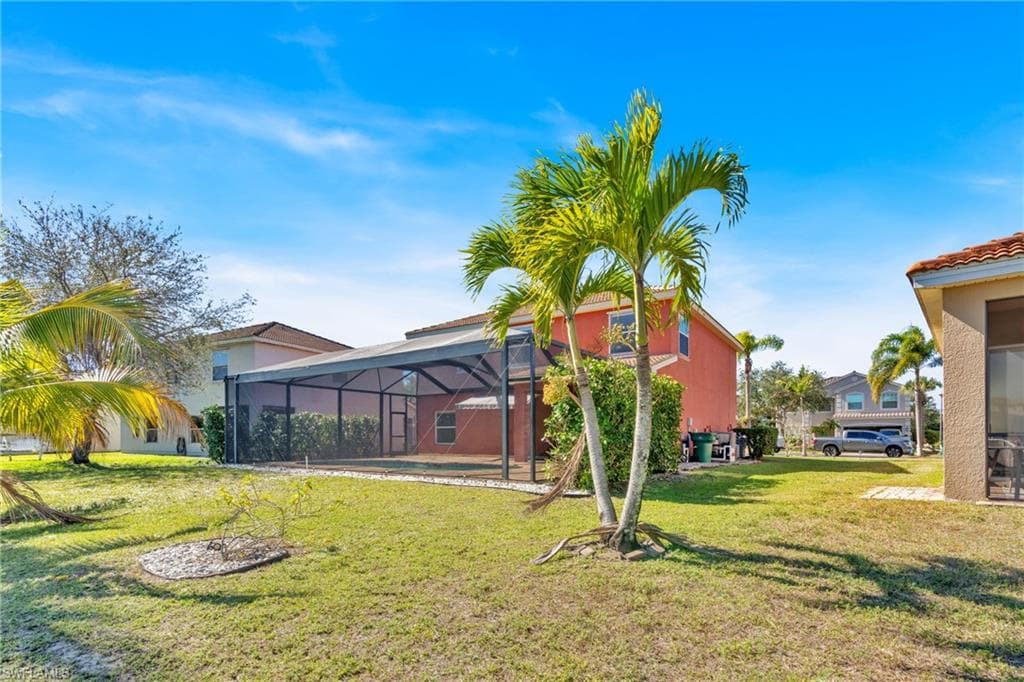 View of green lawn featuring a lanai and a sunroom