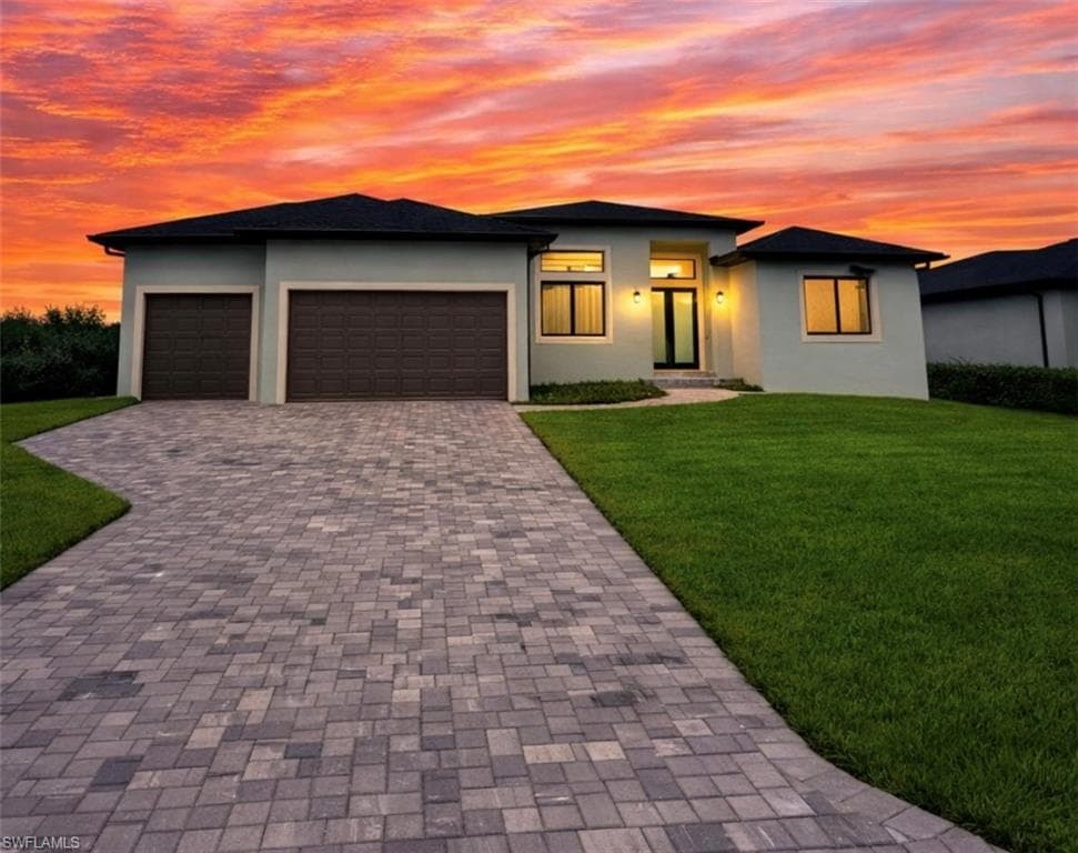Prairie-style home with a front yard, stucco siding, and decorative driveway (Rendered photo)