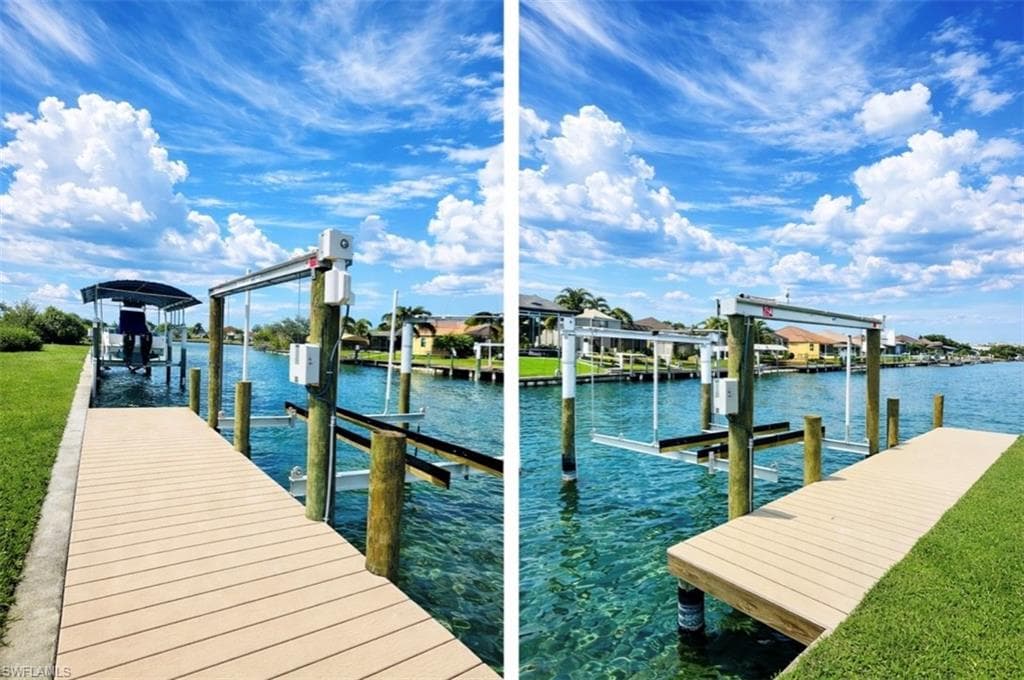 Dock featuring boat lift, a water view, and a yard