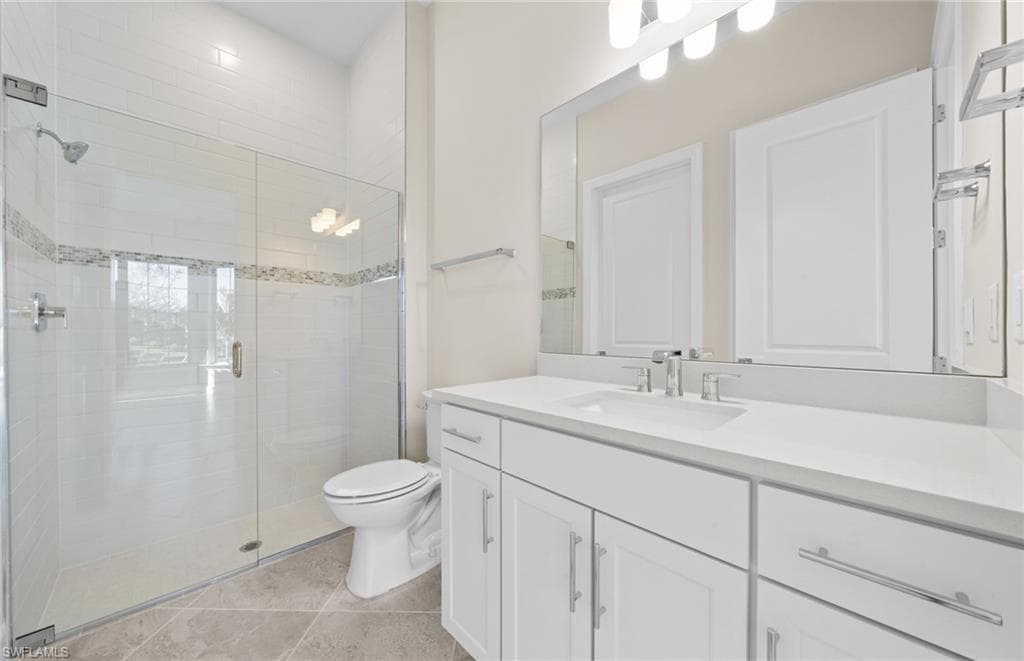 Bathroom with vanity, a shower stall, and light tile patterned floors