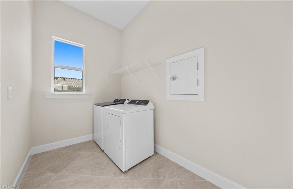 Laundry area featuring washer and clothes dryer and light tile patterned flooring