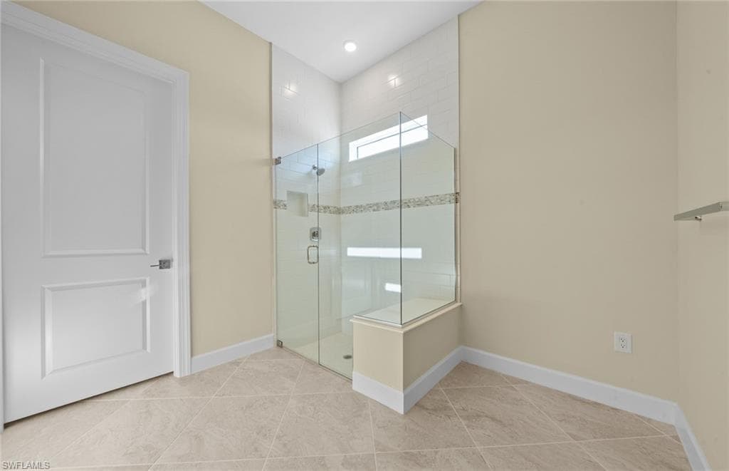 Bathroom featuring a stall shower, light tile patterned floors, and recessed lighting
