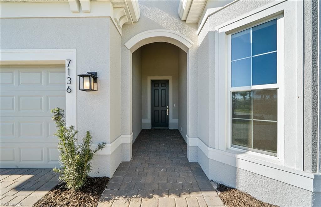 View of exterior entry with stucco siding
