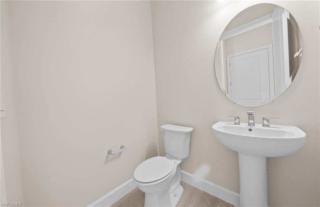 Bathroom featuring toilet and light tile patterned floors