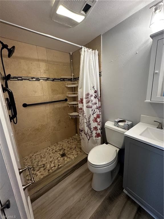 Full bath featuring vanity, a shower stall, and dark wood finished floors