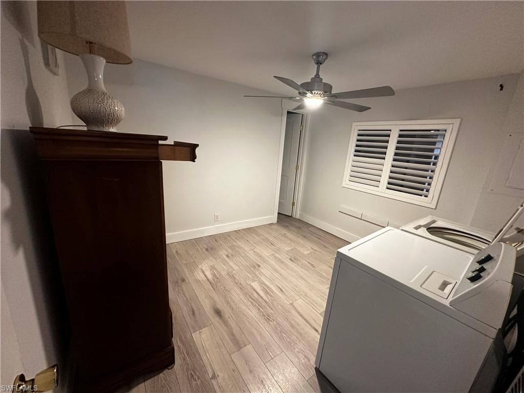 Laundry area with light wood-type flooring, ceiling fan, and washer and dryer