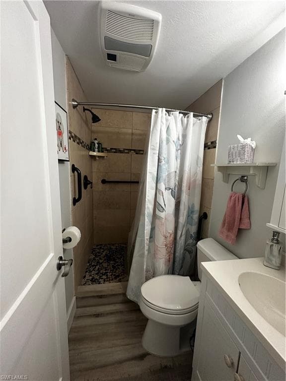 Bathroom featuring a shower stall, vanity, and dark wood-style flooring