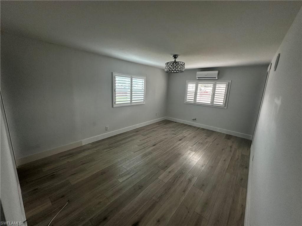 Unfurnished room with wood-type flooring and a mini split for heating / cooling