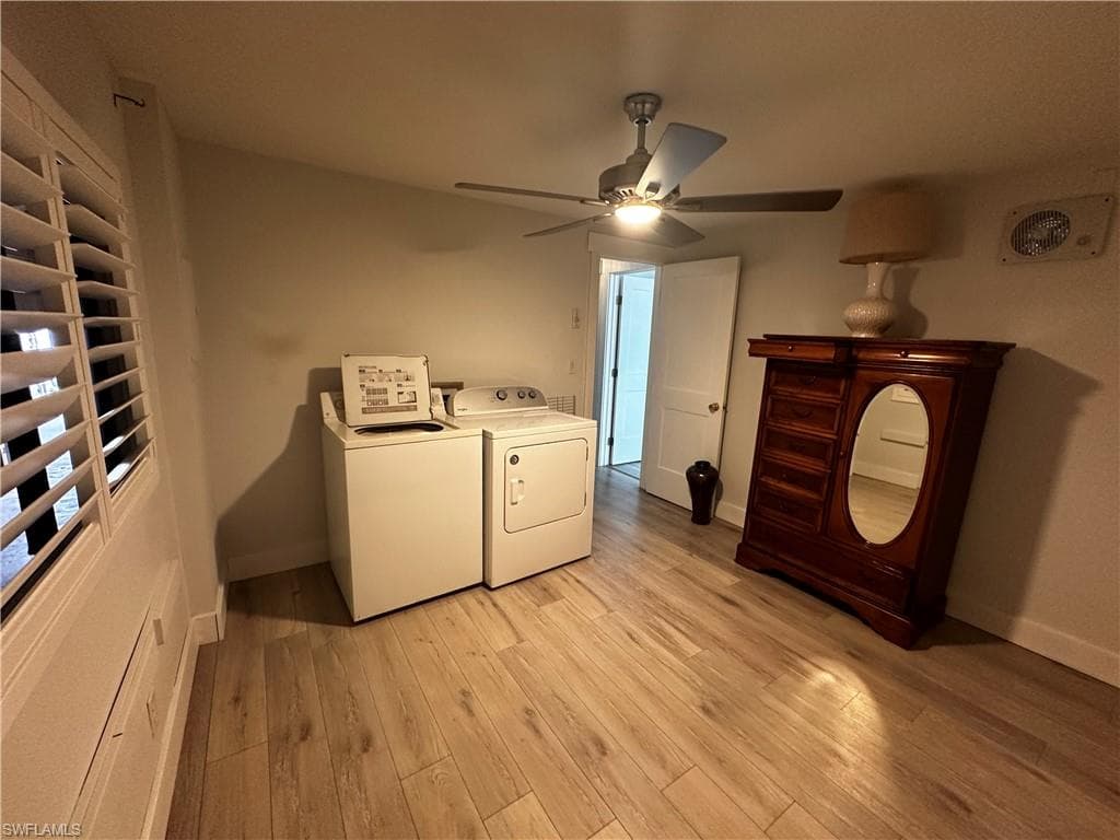 Laundry area featuring independent washer and dryer, light wood-type flooring, and a ceiling fan