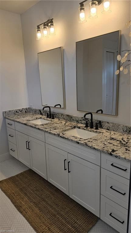 Full bathroom with double vanity and baseboards
