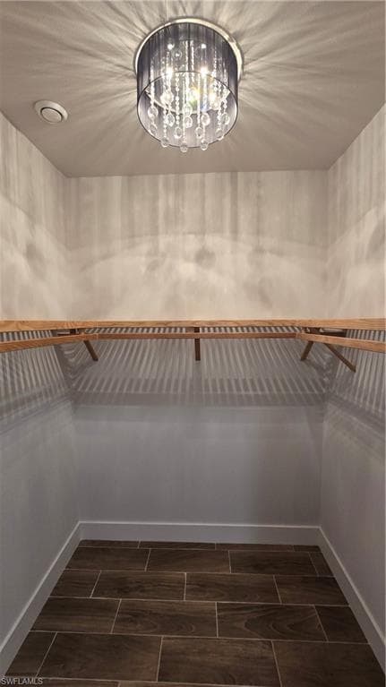 Walk in closet featuring wood tiled floors and suspended lighting