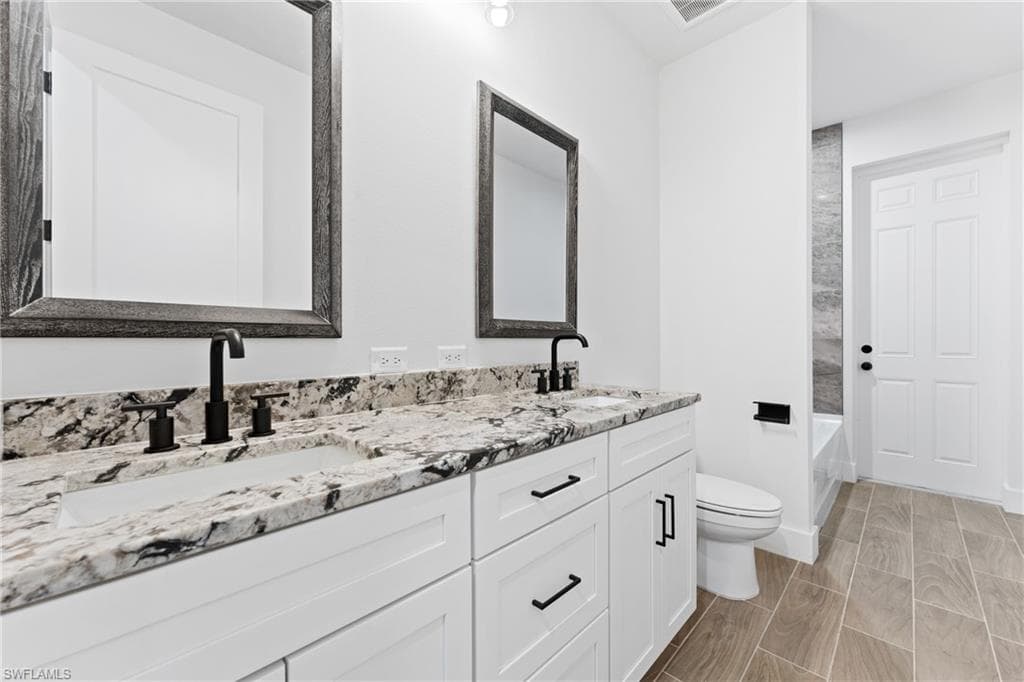 Bathroom featuring double vanity and shower combination