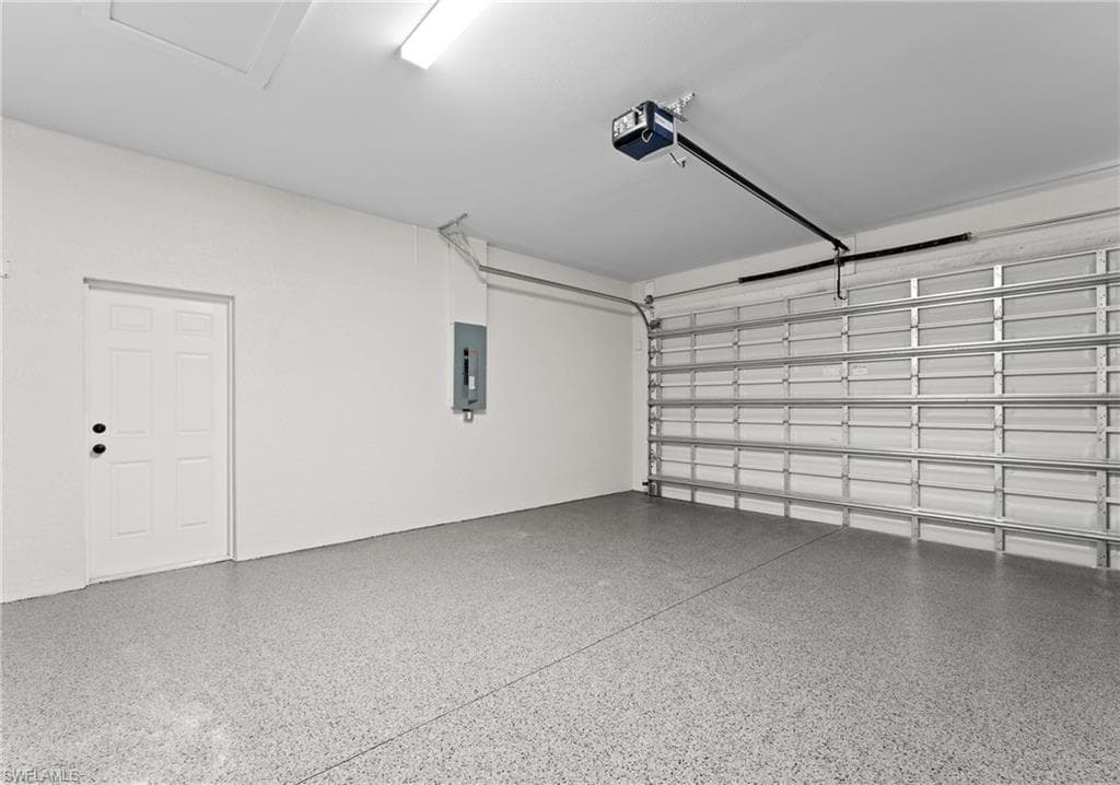 Garage featuring electric panel and a garage door opener