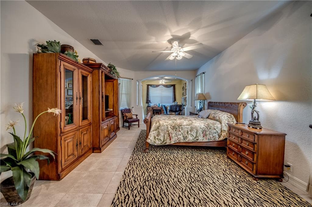 Bedroom with a ceiling fan and light tile patterned floors
