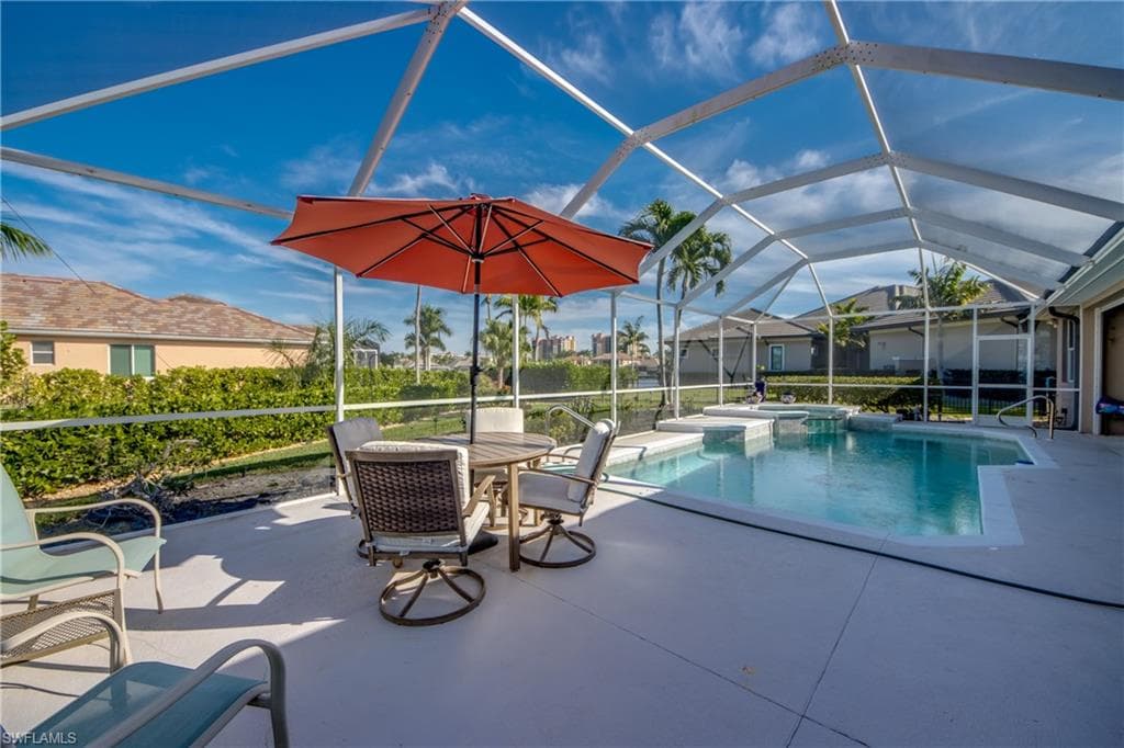 Combined pool / hot tub with a sunroom, a lanai, a patio area, and outdoor dining space