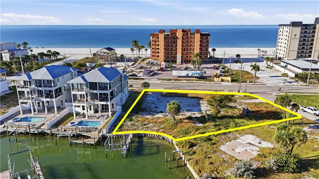 Aerial view of property and surrounding area with a large body of water and property boundaries highlighted - Virtually Edited Image