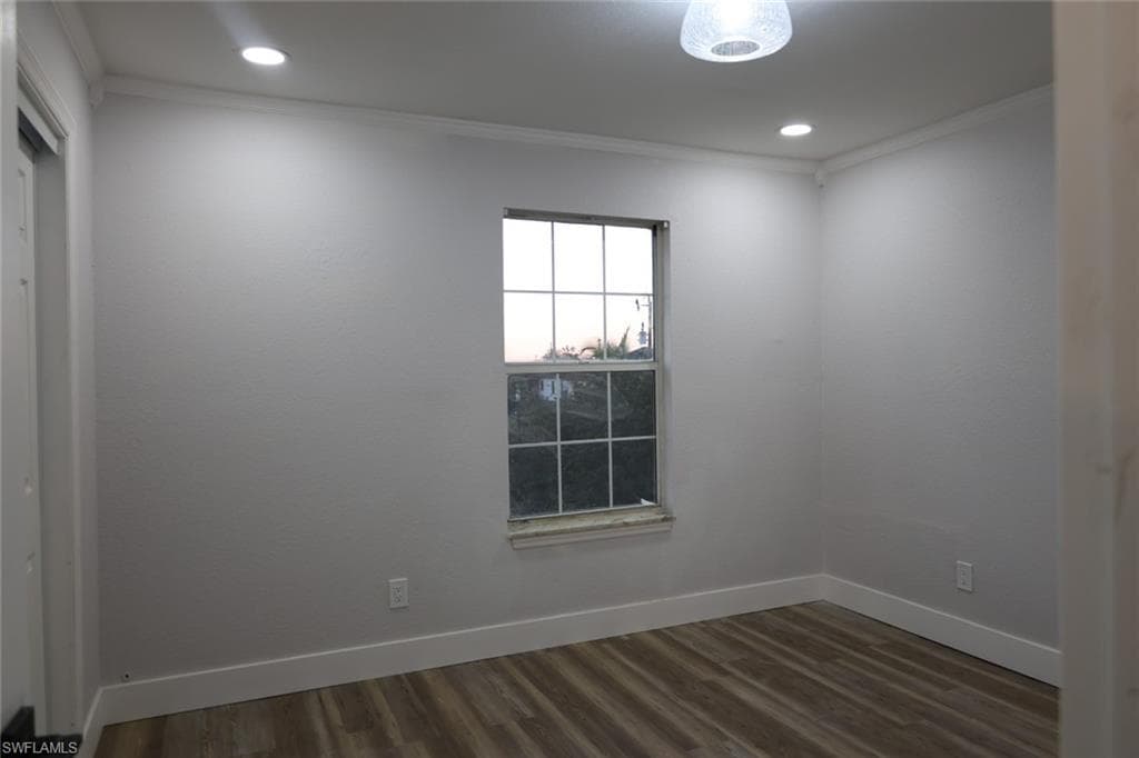 Empty room with crown molding, wood finished floors, and recessed lighting
