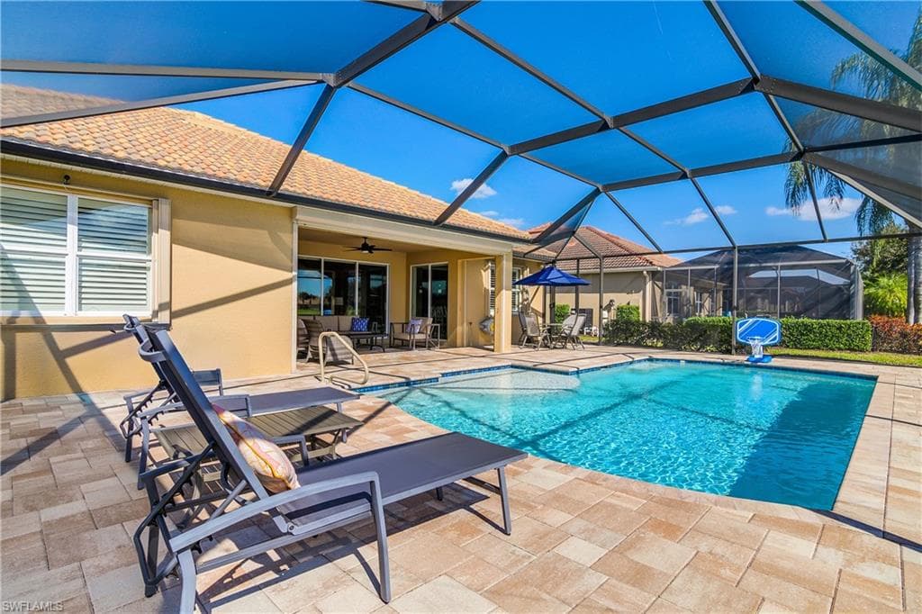Outdoor pool featuring a patio area, a sunroom, and a lanai
