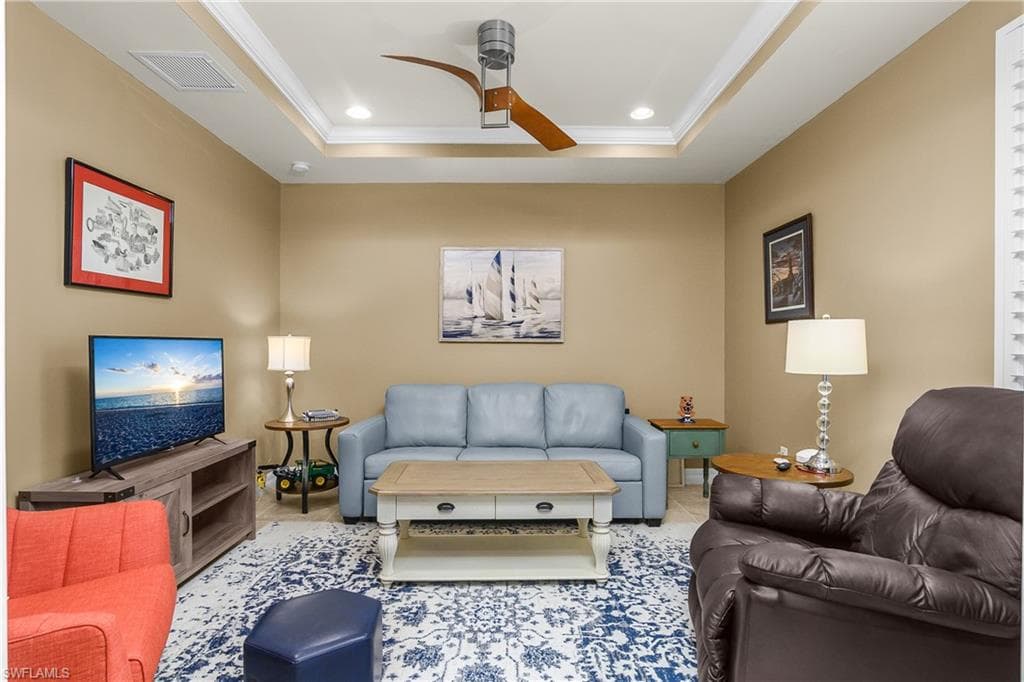 Living area with ceiling fan, recessed lighting, ornamental molding, and a raised ceiling