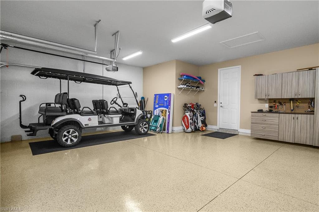 Garage featuring a garage door opener and concrete block wall