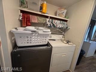 Laundry room with dark wood-style flooring and washer and clothes dryer