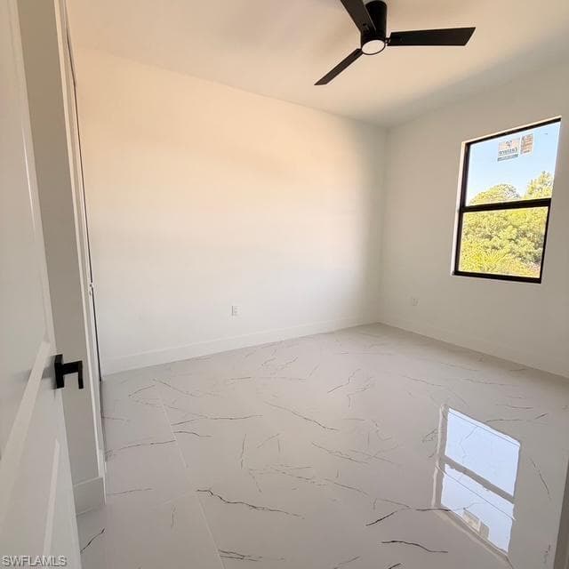 Unfurnished room with ceiling fan and baseboards
