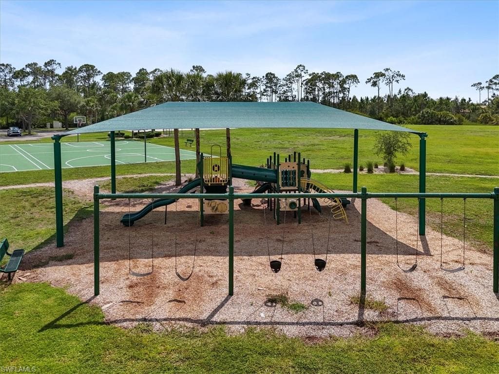 Community playground featuring a lawn and community basketball court