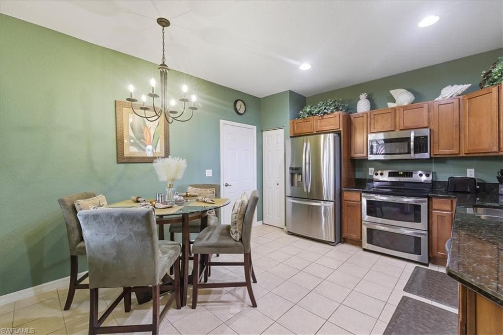 Dining space with light tile patterned flooring, arched walkways, and hanging lights