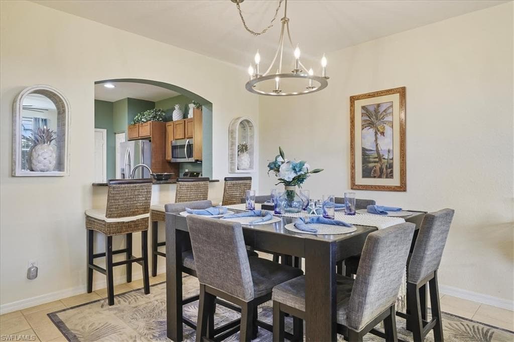 Dining space featuring ceiling fan, light tile patterned flooring, and hanging lights