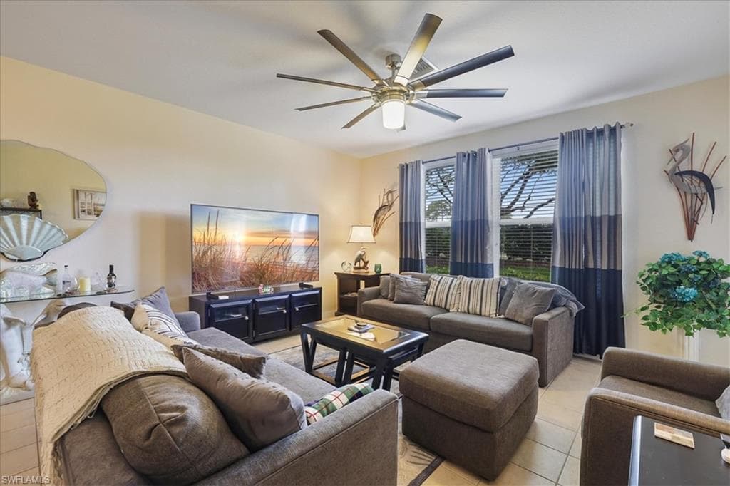 Living area featuring a ceiling fan and light tile patterned floors