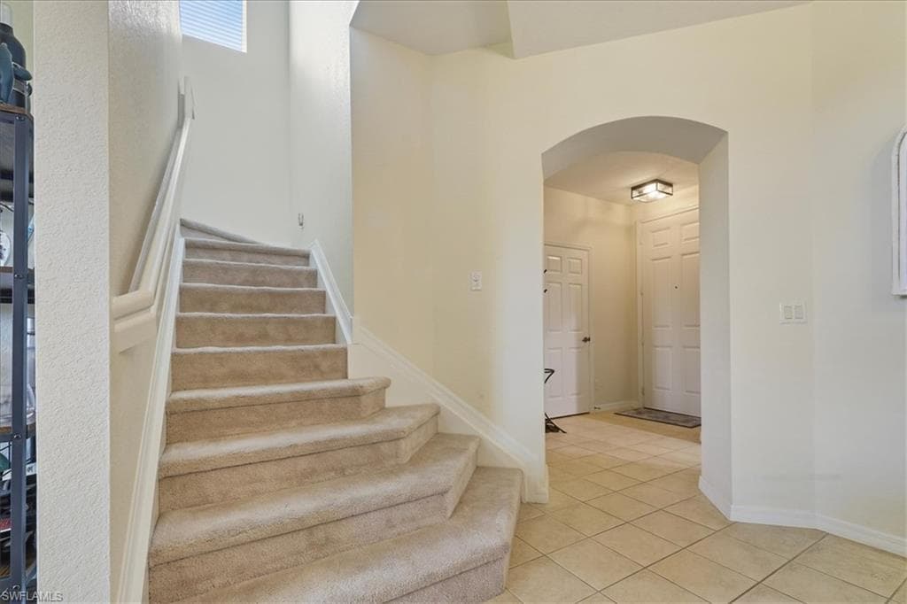 Hallway with light carpet, an upstairs landing, and a chandelier