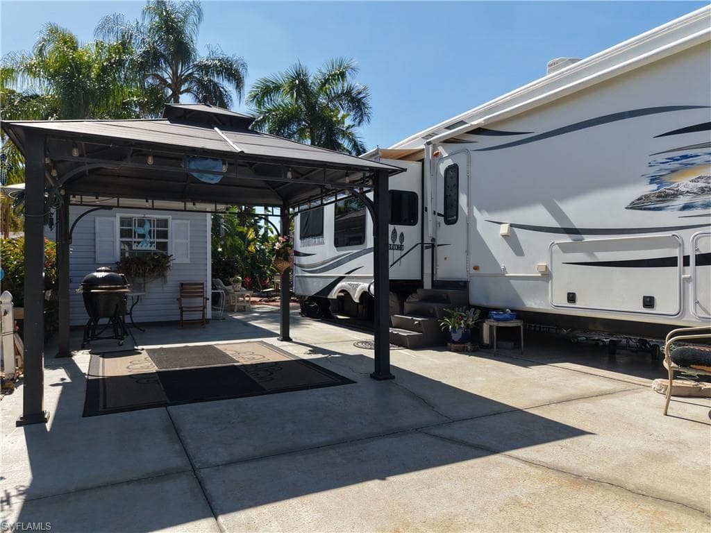 View of patio with a gazebo, a grill, and entry steps