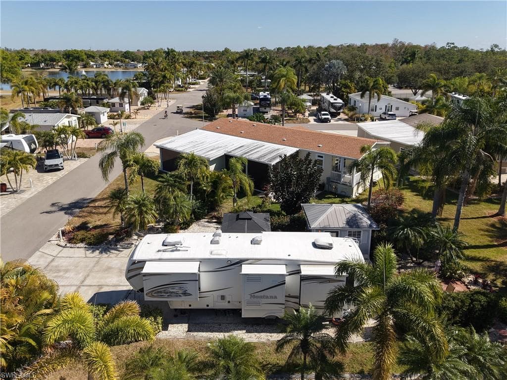 Aerial view of residential area featuring a tree filled landscape and a large body of water