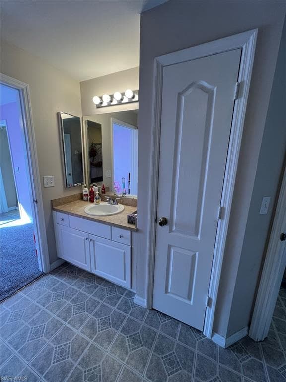 Bathroom featuring vanity and dark tile patterned flooring