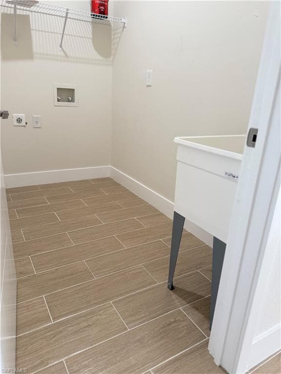 Laundry area featuring hookup for an electric dryer, hookup for a washing machine, and wood tiled floors
