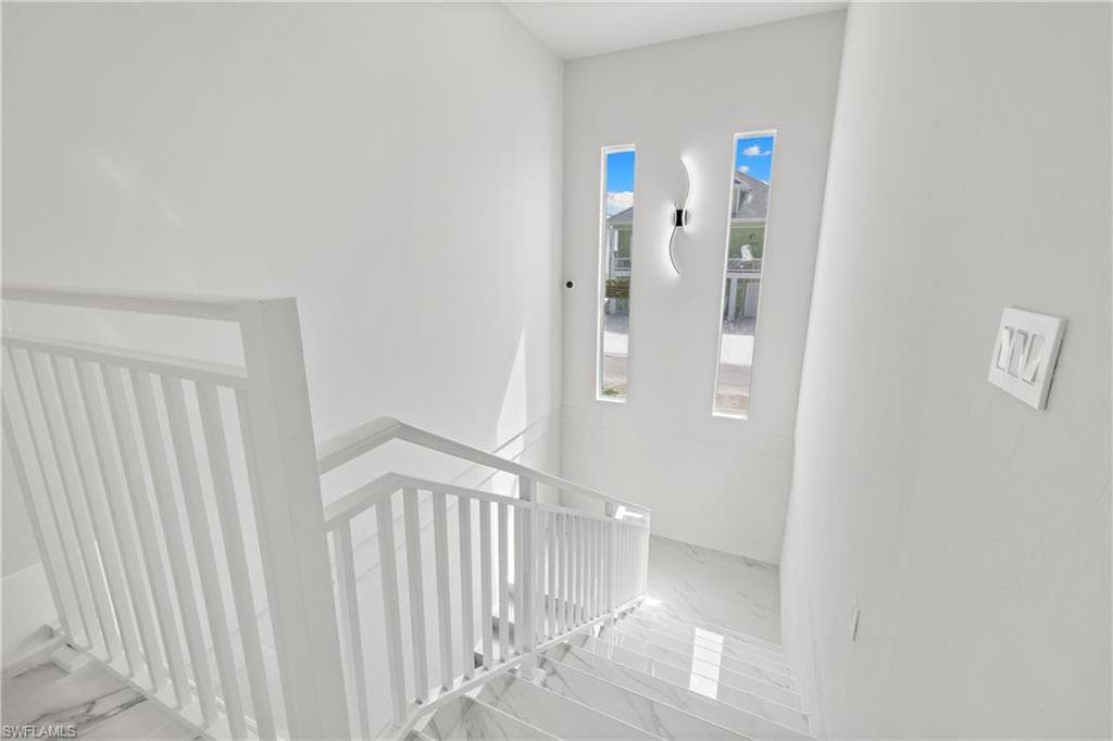 Stairs featuring marble look tile flooring
