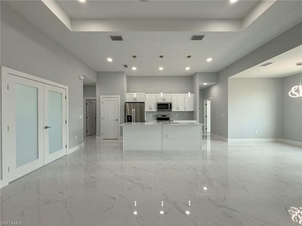 Unfurnished living room with baseboards, visible vents, and recessed lighting