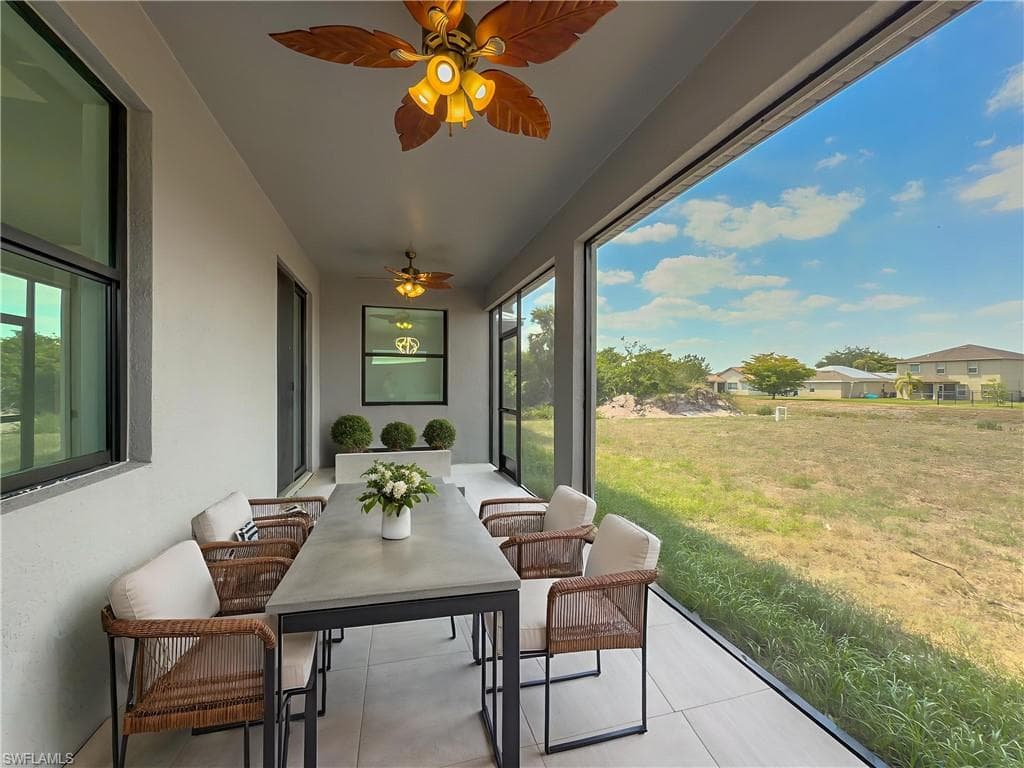 Sunroom / solarium with ceiling fan and tile patterned flooring