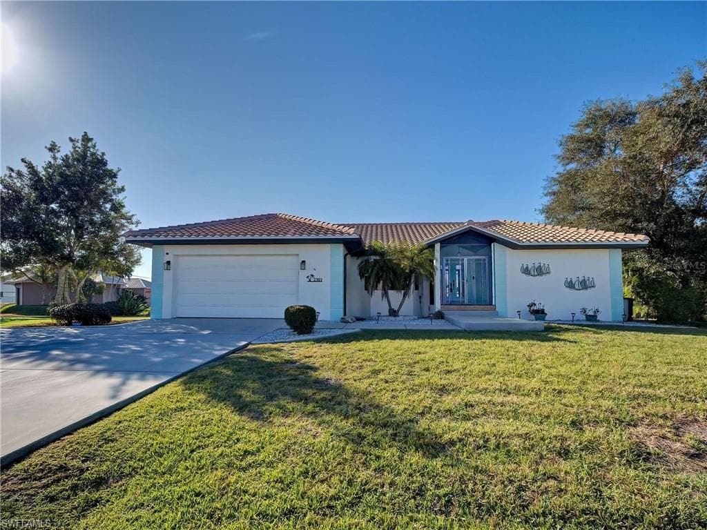 Mediterranean / spanish-style home with concrete driveway, a tile roof, a front yard, and stucco siding
