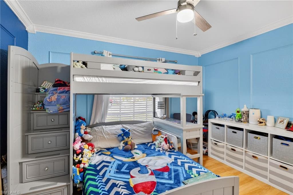 Bedroom featuring crown molding, light wood-type flooring, and ceiling fan